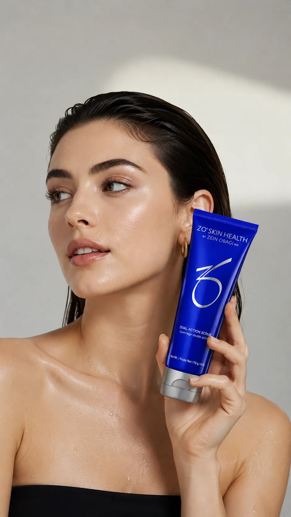 Model holding a blue skincare tube