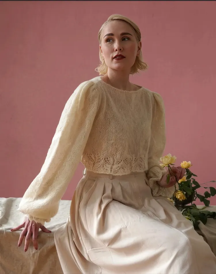 Model in a cream lace blouse and skirt