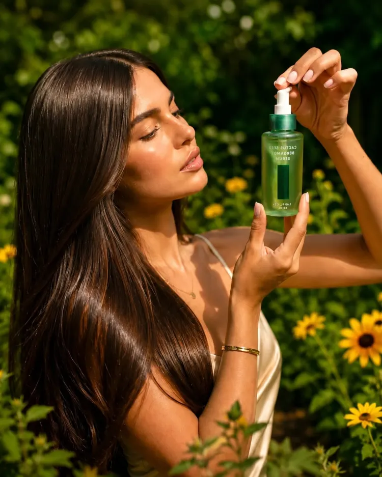 Woman applying a botanical hair oil outdoors